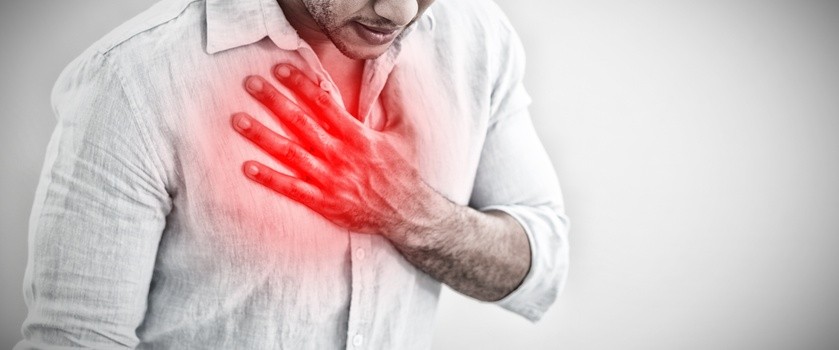 Mężczyzna trzymający się za klatkę piersiową z powodu bólu płuc. Obszar płuc zaznaczono na czerwono.