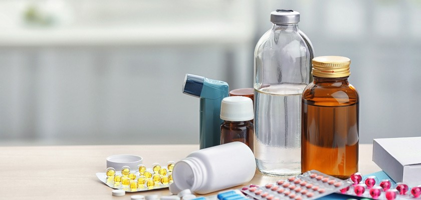 Różne rodzaje leków na drewnianym stole.