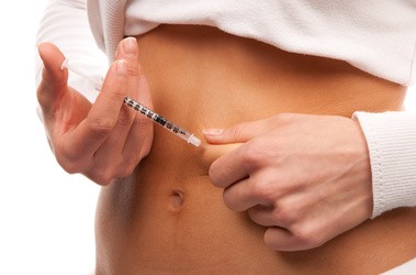 Pacjent z cukrzycą używa strzykawki z insuliną.