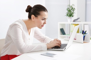 Kobieta garbi się przed laptopem
