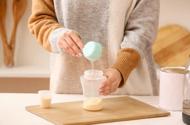 Kobieta przygotowująca mleko dla dziecka w kuchni