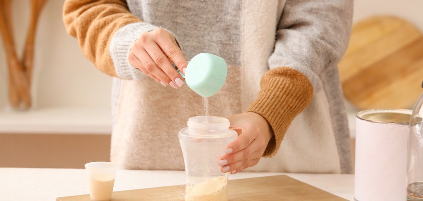 Kobieta przygotowująca mleko dla dziecka w kuchni