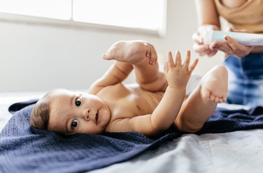 Mama aplikuje na skórę niemowlaka balsam przeciwko odparzeniom