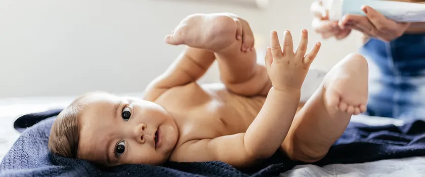 Mama aplikuje na skórę niemowlaka balsam przeciwko odparzeniom