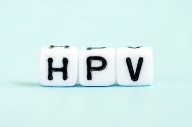 Napis HPV na kostkach na miętowym tle.