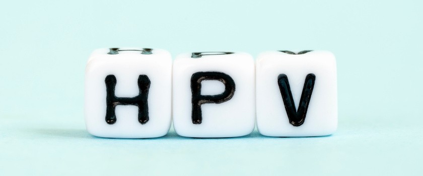 Napis HPV na kostkach na miętowym tle.