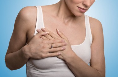 Portret młodej kobiety z bólem piersi  podczas dotykania piersi