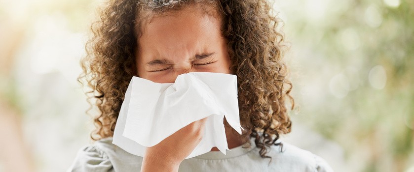 Chora mała dziewczynka wydmuchuje nos. Dziecko cierpiące na zatoki lub alergie.