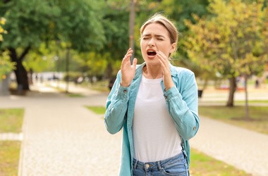 Młoda kobieta cierpiąca na alergię na zewnątrz