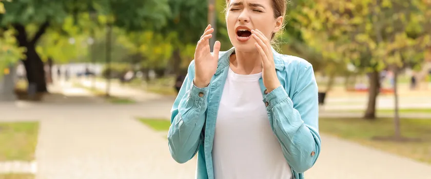 Młoda kobieta cierpiąca na alergię na zewnątrz