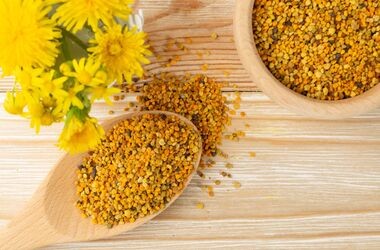 Pyłek pszczeli na drewnianej łyżce, kwiaty. Pyłek kwiatowy.