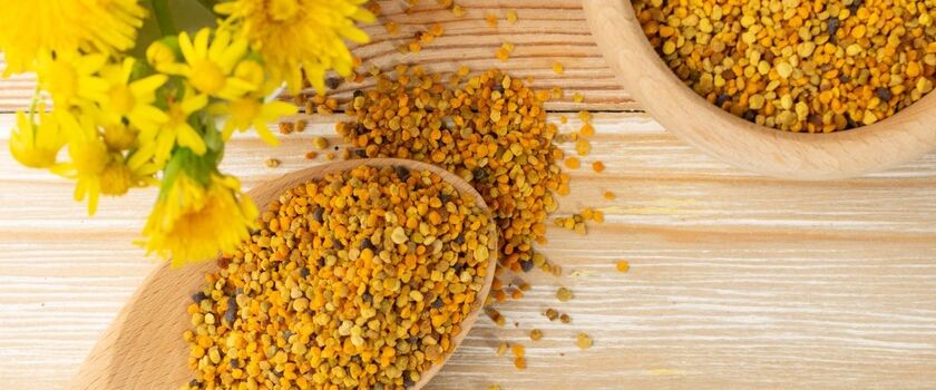 Pyłek pszczeli na drewnianej łyżce, kwiaty. Pyłek kwiatowy.