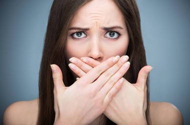Kobieta zakrywające swoje usta z powodu brzydkiego zapachu.