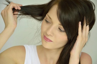 Młoda kobieta dotykająca swoich włosów