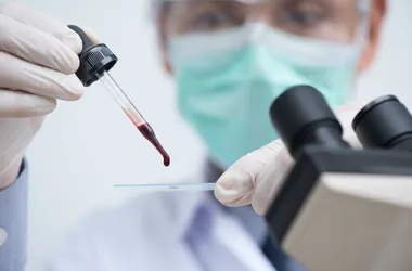 Diagnosta w laboratorium przygotowuje krew do badania.