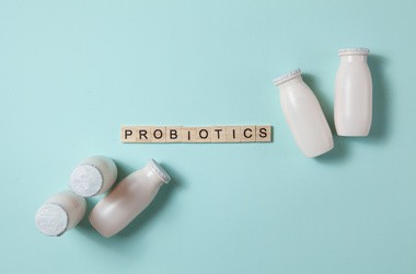 Butelki z probiotykami w napoju mlecznym na jasnoniebieskim tle