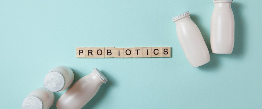 Butelki z probiotykami w napoju mlecznym na jasnoniebieskim tle