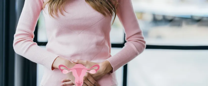 Kobieta trzymająca ręce w strefie intymnej. Możliwie z powodu zespołu policystycznych jajników (PCOS).