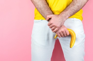 Impotencja: mężczyzna w białych spodniach trzymający banana