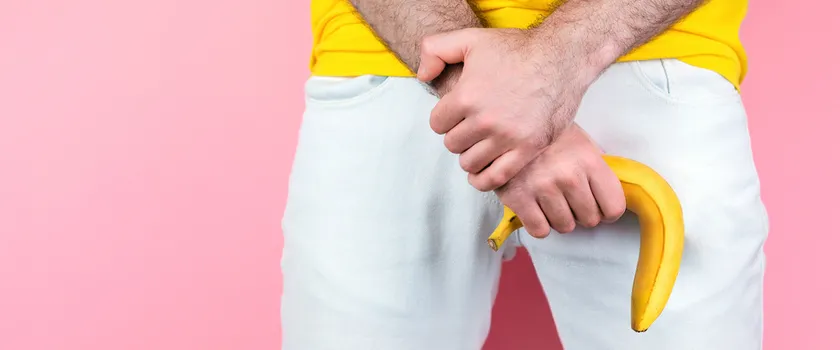 Impotencja: mężczyzna w białych spodniach trzymający banana