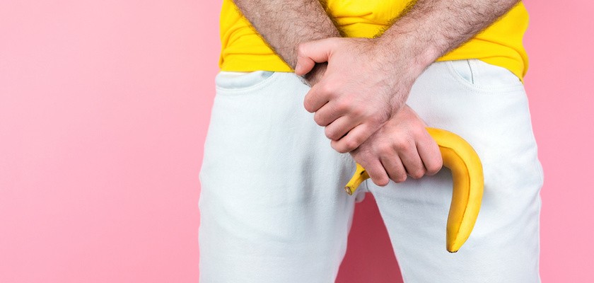 Impotencja: mężczyzna w białych spodniach trzymający banana